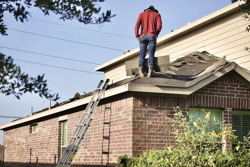 Professional roofer working on a residential roof in Butlerville